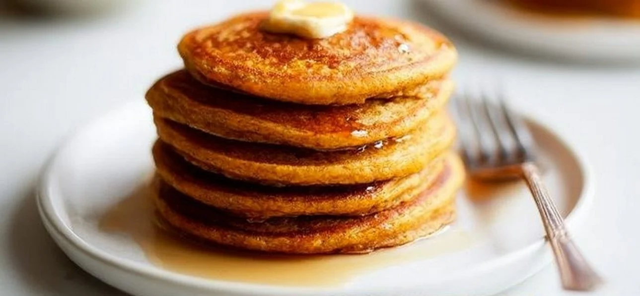 Oatmeal pumpkin pancakes stacked with syrup and cinnamon on a plate